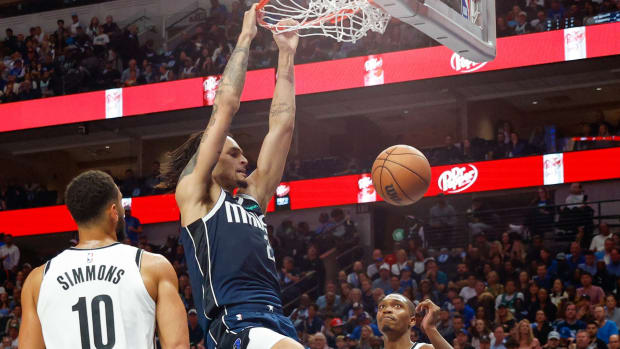 Dereck Lively II slams home a dunk as Ben Simmons and Lonnie Walker IV look on.